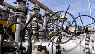 عامل يفحص صمامات في مصفاة نفط بالبصرة بالعراق