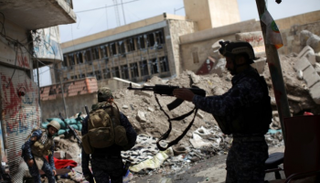 الشرطة العراقية في مناطق محررة غرب الموصل (رويترز)