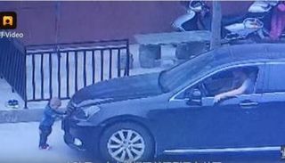 الطفل الصيني أثناء وقوفه أمام السيارة