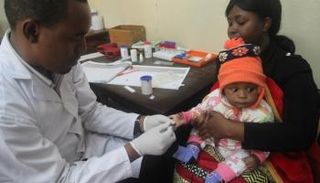 طبيب يفحص طفلا للكشف عن الملاريا