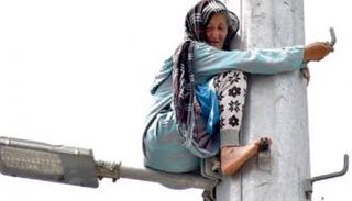 السيدة عايشة تهدد بانتحار من أعلى عمود للاتصالات