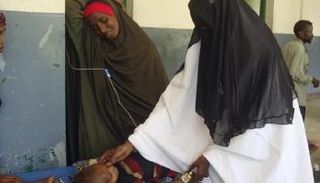 طبيبة صومالية تعالج طفلا مصابا بسوء التغذية في مستشفى في مقديشو