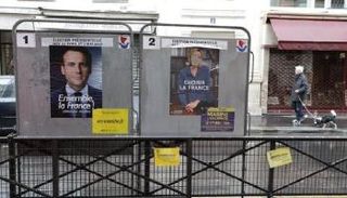 ملصقان دعائيان لمرشح الوسط إيمانويل ماكرون ومنافسته لوبان