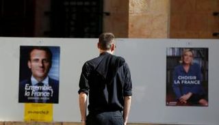 مواطن فرنسي حائر بين إعلاني ماكرون ولوبان (رويترز)