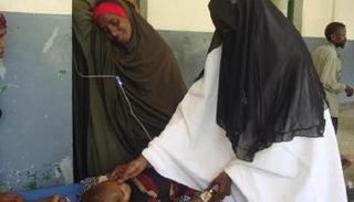 طبيبة صومالية تعالج طفلا مصابا بسوء التغذية في مستشفى في مقديشو