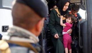 جندي عراقي يؤمن الفارين من داعش إلى حمام العليل جنوب الموصل (رويترز)