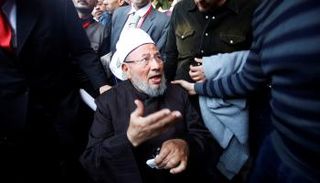 القرضاوي وسط مناصريه من تنظيم الإخوان الإرهابي (رويترز)