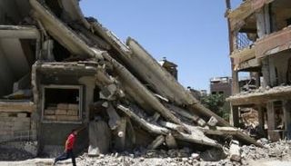 طفل سوري أمام بناية مهدمة في مدينة دوما