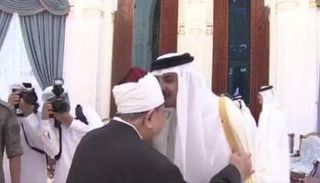 قبلة طبعها تميم على رأس مفتي الإرهاب القرضاوي