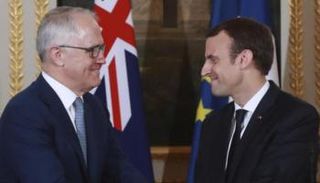 إيمانويل ماكرون يصافح مالكولم ترنبول خلال مؤتمر صحفي في باريس