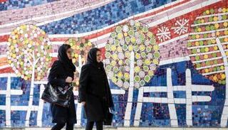 إيرانيتان تسيران بأحد شوارع طهران