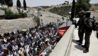 فلسطينيون يصلون خارج الأقصى (رويترز)