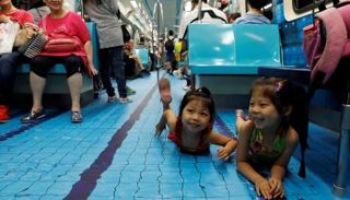 أطفال يتفاعلون مع قطار زينت أرضيته بملاعب رياضية