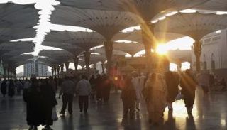 أشخاص يسيرون امام الحرم النبوي بالمدينة المنورة