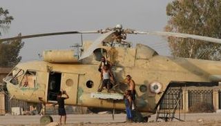 مواطنون يلتقطون صورة أمام طائرة عسكرية في دير الزور - رويترز