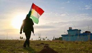 مقاتل كردستاني يحمل علم الإقليم - أرشيفية