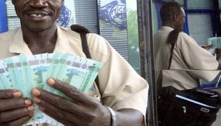 سوادني يفرز عملات ورقية للجنيه - أرشيف