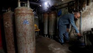 عامل يملأ أسطوانة بالغاز المسال في كراتشي - رويترز