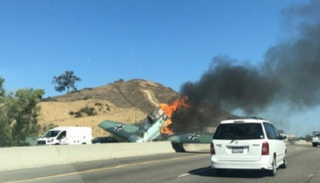 سيارات تمر بالقرب من حطام طائرة تعود إلى الحرب العالمية الثانية