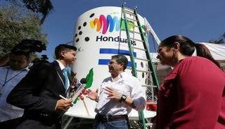 رئيس هندوراس خوان أورلاندو هرنانديس وزوجته أمام فنجان قهوة عملاق