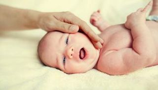 التربيت اللطيف على جسد الطفل يساعد على تخفيف الألم - صورة أرشيفية