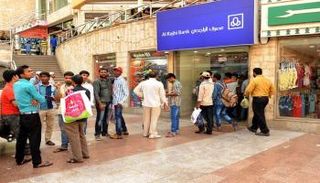 عمالة وافدة أمام أحد فروع مصرف الراجحي