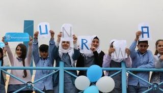 لاجئون فلسطينيون يرفعون شعار "الأونروا"