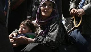 طفل مع امرأة سورية خلال عمليات الإجلاء من الغوطة الشرقية- أرشيفية