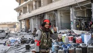 عنصر من الفصائل الموالية لتركيا يحتفل بسرقة منازل عفرين