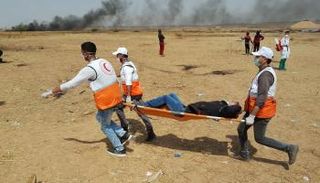 مسعفون يحملون مصابا خلال مسيرات اليوم