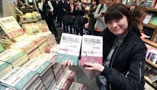  جمهور موراكامي يلتقطون صورا مع إحدى إصداراته فور طرحها بالمكتبات