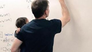 أستاذ جامعي يحمل رضيع إحدى طالباته