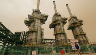 عامل يمشي في حقل الزبير النفطي في البصرة