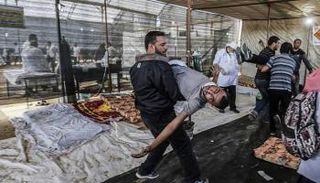 فلسطيني يحمل شهيدا قتل برصاص الاحتلال