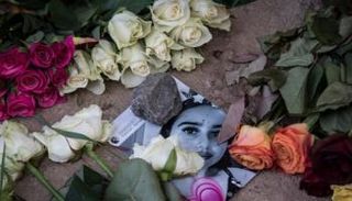 صورة لسوزانا بين الزهور في نصب تذكاري في موقع الاعتداء عليها - أ.ف.ب