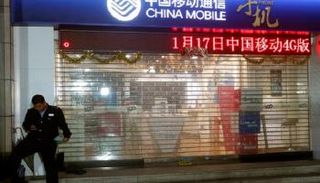 حارس أمام متجر لشركة تشابنا موبايل- رويترز