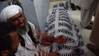 أحد الضحايا يبكي على فقدان أحد ضحايا الهجوم- (أ ف ب)