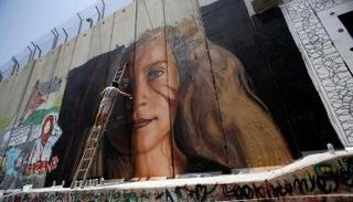 فنان الجرافيتي الإيطالي جوريت آجوش يعمل على لوحة عهد التميمي