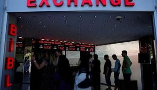 أتراك يقومون بتغيير الليرة في أحد مكاتب الصرافة بإسطنبول