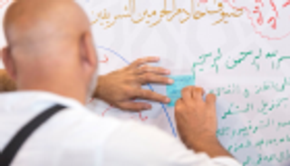 بالصور.. أكبر جدارية بمشعر منى ينثر عليها ضيوف الملك سلمان مشاعرهم