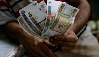 رجل يحمل البيزو الكوبي