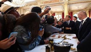 الرئيس الفرنسي إيمانويل ماكرون يصافح زوار قصر الإليزيه