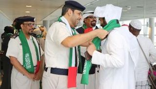 شرطة أبوظبي تستقبل السعوديين بالورود والأعلام احتفاء بيومهم الوطني 