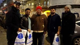 متطوعو الجمعية يوزعون الوجبات في أكياس كتب عليها 