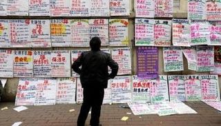 صيني يقرأ لافتات عليها معلومات عن وظائف ..رويترز