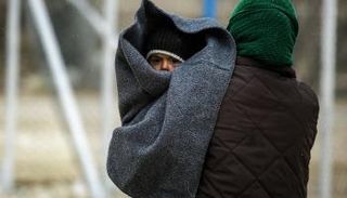 أم سورية تحمل طفلها في مخيم الهول