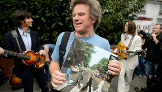 معجب بفرقة "البيتلز" يمسك بصورتها الأشهر 