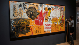 موظفة في دار "سوذبيز" للمزادات قرب لوحة لجان ميشال باسكيا 