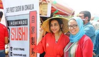 دينا عرفة (على اليمين) إلى جوار لافتة