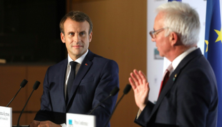 بيتر ساندز (يمين) متحدثاً إلى جانب الرئيس الفرنسي إيمانويل ماكرون